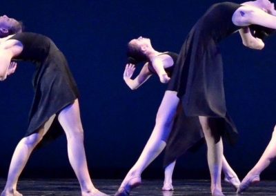 Dance Cavise dancers on stage in black dresses performing a modern dance at a performance at SUNY Purchase