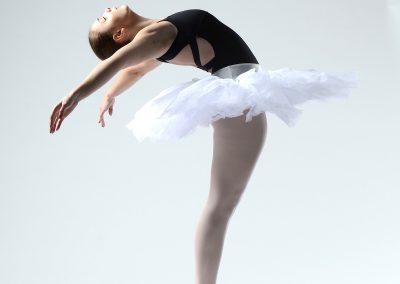 Dance Cavise ballet student posed on point in white ballet tutu and black leotard